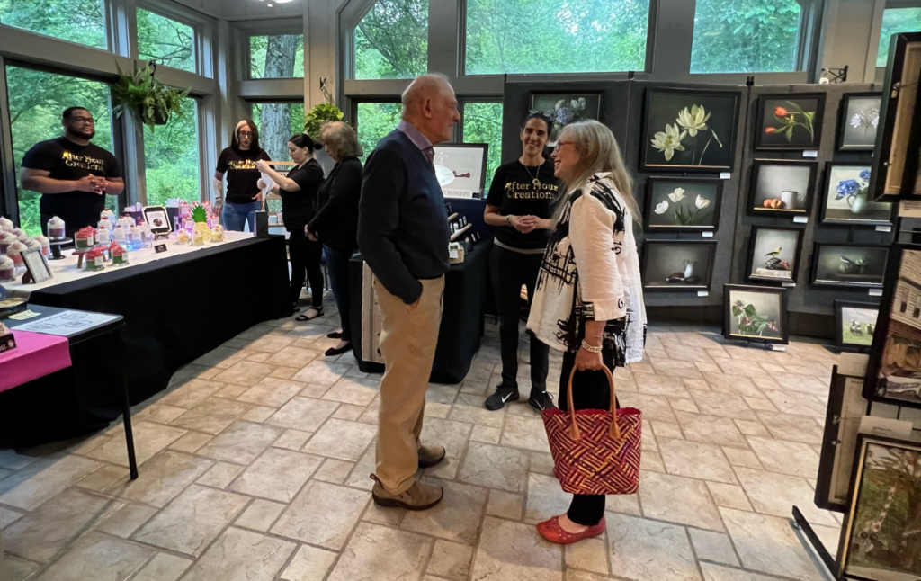 Visitors browsing artwork and talking with artists at Sherman ArtFest