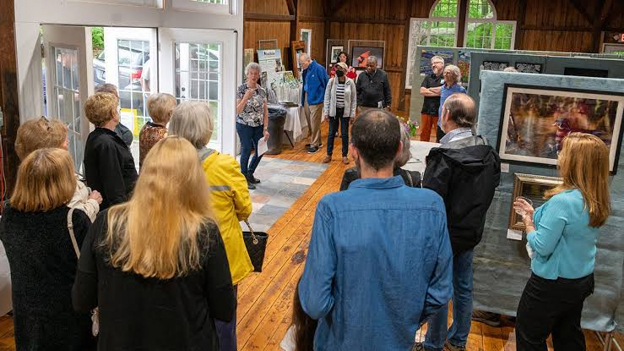 Visitors viewing artwork at the Great Hollow art show in New Fairfield